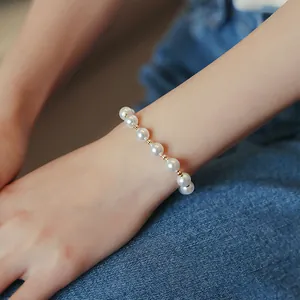 Elegant pearl bracelet with gold spacer beads worn on wrist for a minimalist jewelry look