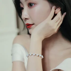Elegant minimalist pearl bracelet with gold spacers shown on woman's wrist detail view
