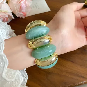 Close-up of a vintage acrylic marbled bracelet featuring chunky gold and green oval links.
