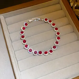 Detailed view of a silver-tone bracelet with sparkling round red zircon stones