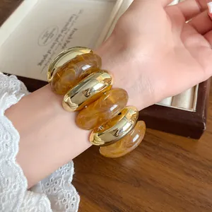 Macro view of retro marbled acrylic and golden metallic segment chunky bracelet