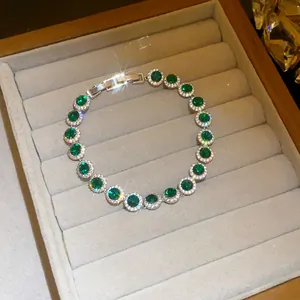 Detailed view of sparkling emerald green cubic zirconia bracelet in a velvet gift box