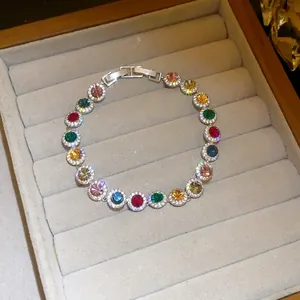Close-up of sparkling colorful zircon round link bracelet in a grey velvet jewelry box