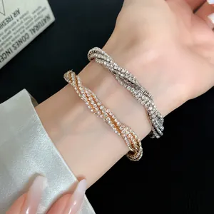 Close-up of gold and silver multi-layer rhinestone bracelets on a wrist.
