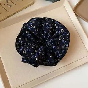 Scrunchie floreale vintage blu scuro su un vassoio minimalista elegante
