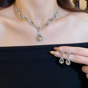 Nahaufnahme eines Set aus Tropfenhalskette und Blumenohrringen im Palaststil mit Strass
