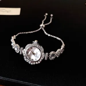 Montre bracelet argentée ronde en strass élégante avec mouvement à quartz de luxe.