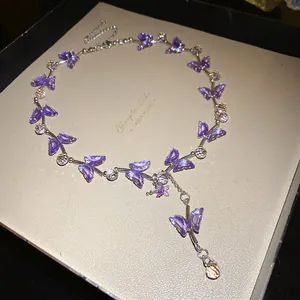 Detailaufnahme einer eleganten lila Glas-Schmetterlingshalskette mit Wassertropfen
