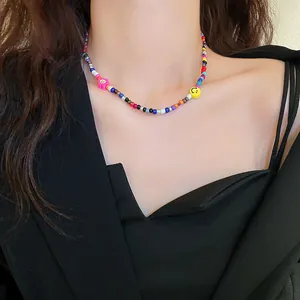 Detailansicht einer bunten Perlenkette mit einer Blume und einem Smiley-Anhänger.