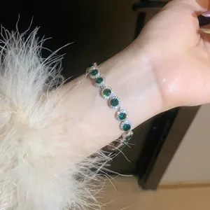 Macro view showing the detail of a sparkling round green zircon bracelet in silver