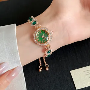 Vue détaillée d'une élégante montre bracelet en or rose avec cadran vert et lunette en strass