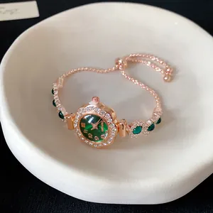 Vue détaillée d'une montre bracelet élégante en or rose avec un cadran vert émeraude