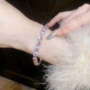 Detailed view of sparkling round pink zircon bracelet with halo setting on wrist