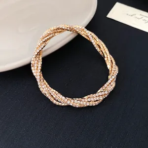 Elegant multi-layer gold bracelet with sparkling rhinestones in a twisted geometric design