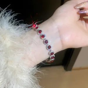 Close-up of elegant silver bracelet with round red cubic zirconia crystals on wrist