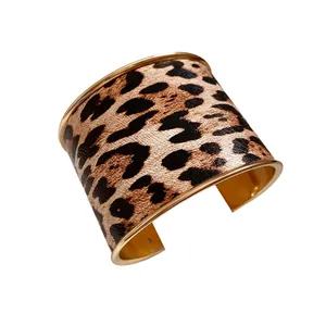Elegant wide leopard print leather cuff bracelet with polished gold-toned metal edges