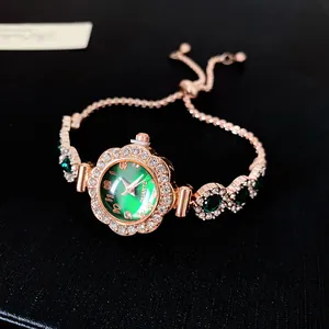 Vue détaillée d'une montre bracelet élégante en or rose avec cadran vert et lunette en cristal