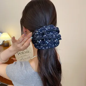 Dettaglio di un elastico per capelli vintage a fiori blu scuro su una coda di cavallo