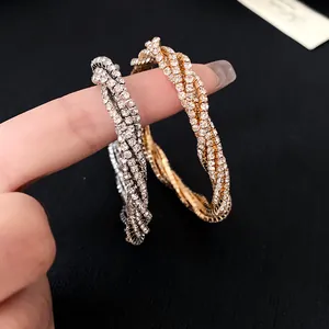 Macro view of gold and silver twisted multilayer bracelets with sparkling rhinestones