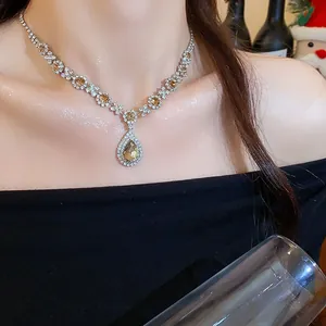 Detailansicht der luxuriösen Tropfen-Halskette mit Champagner-Kristallen am Model-Hals.