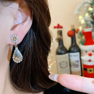 Nahaufnahme von eleganten Tropfenohrringen im Hofstil mit Kristallen und Blumendesign.