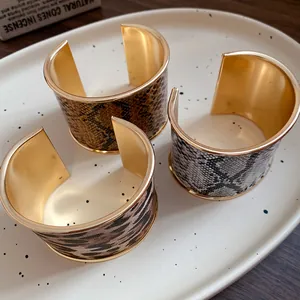 Detail view of wide open cuff bracelets with leopard and snakeskin textures