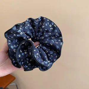 Primo piano di un elastico per capelli vintage in tessuto blu navy a fiori