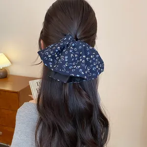 Primo piano di un elastico in tessuto floreale vintage su capelli castani