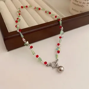 Nahaufnahme der bunten Perlenkette mit Schmetterlingsformen und Silberglocke