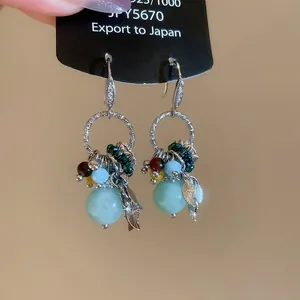 Bohemian-style dangle earrings with light blue stones and silver hooks detail shot.