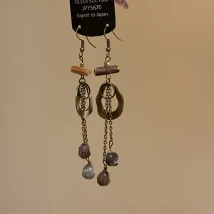 Detail of Bohemian long tassel earrings with antique bronze rings and natural stone beads