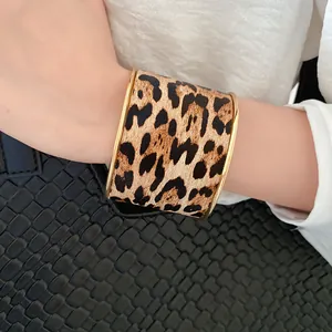 Close-up view of a stylish leopard print cuff bracelet with vintage gold metal edges.