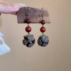 Detailed close-up view of bohemian ethnic earrings featuring red beads and natural nut shells
