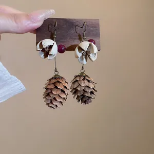 Detailed macro view of bohemian pinecone earrings featuring natural stone beads and petals