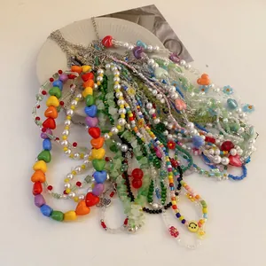 Auswahl an bunten Perlenketten mit Kunstperlen, Herz- und Blumenanhängern für Damen.
