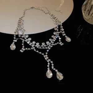Vue détaillée d'un collier élégant en strass argenté avec gouttes d'eau sur noir