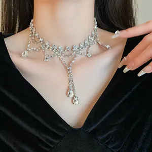 Détail d'un collier ras du cou argenté avec strass et pendentifs en cristal en goutte