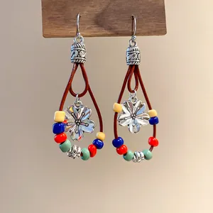 Close-up of Bohemian teardrop earrings with colorful beads and floral pendants