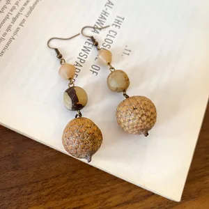 Close-up of vintage bohemian dangle earrings with natural seed and nut beads
