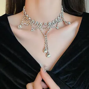 Détail d'un collier élégant à strass avec gouttes d'eau sur fond de velours noir