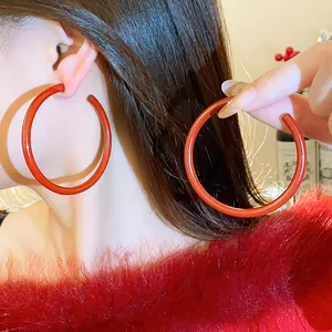 Close-up detail of stylish large red hoop earrings for a festive New Year look