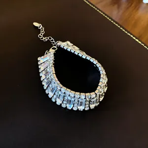 Detailed view of geometric clear crystal rhinestone choker on a dark leather background