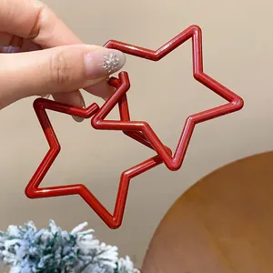 Close-up of vibrant red star-shaped hoop earrings for a stylish festive holiday look