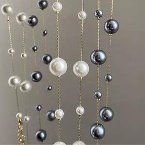 Dettaglio macro di una collana lunga vintage francese con perle grigie e bianche