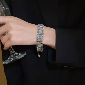 Close-up of an elegant sparkling geometric crystal bracelet paired with a black blazer