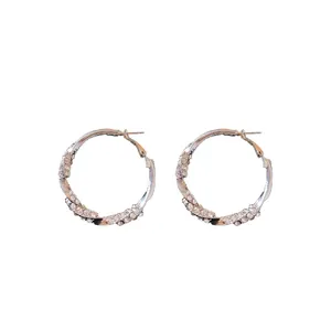 Eleganti orecchini a cerchio ritorti color argento con strass scintillanti.