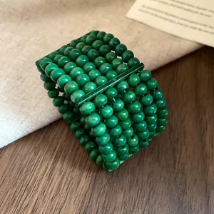 Close-up detail of multi-layer green wooden bead bracelet with vintage ethnic style