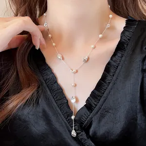 Elegante collana a Y con perle irregolari e grani argentati su camicetta nera