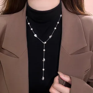 Dettaglio di un'elegante collana a Y con perle irregolari e perline in metallo argento
