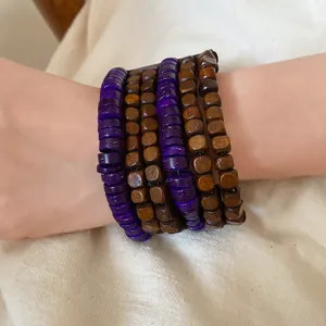 Detailed view of multilayered ethnic style bracelet with purple and brown wooden beads